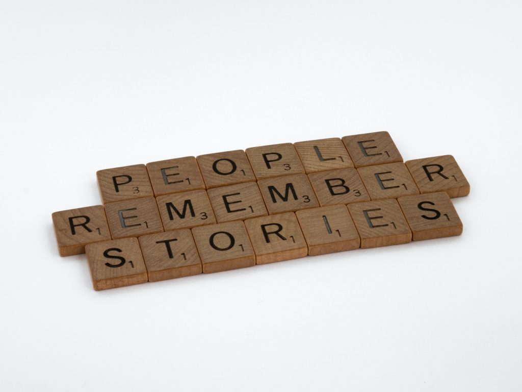 wooden alphabet squares spelling out "people remember stories"