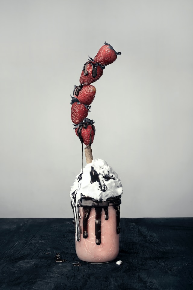 strawberries balancing on a smoothie straw