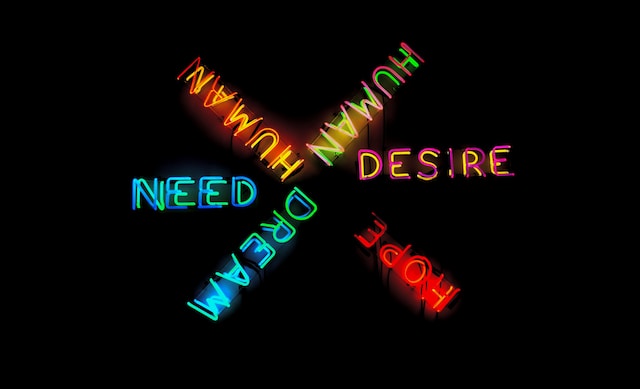 neon sign saying "need" and "desire"